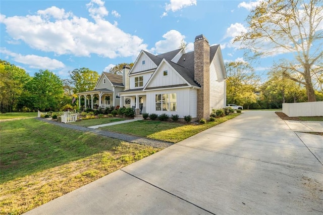 352 Davis St, Monroe, GA 30655 - view of front facade featuring board and batten siding, a front lawn, driveway, and a chimney