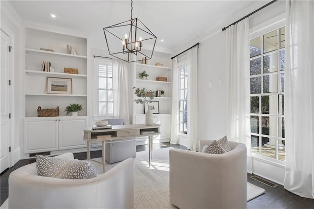 living area with ornamental molding, dark hardwood / wood-style flooring, built in features, and an inviting chandelier