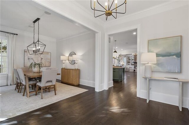 dining space featuring dark wood-type flooring, ornamental molding, and a chandelier