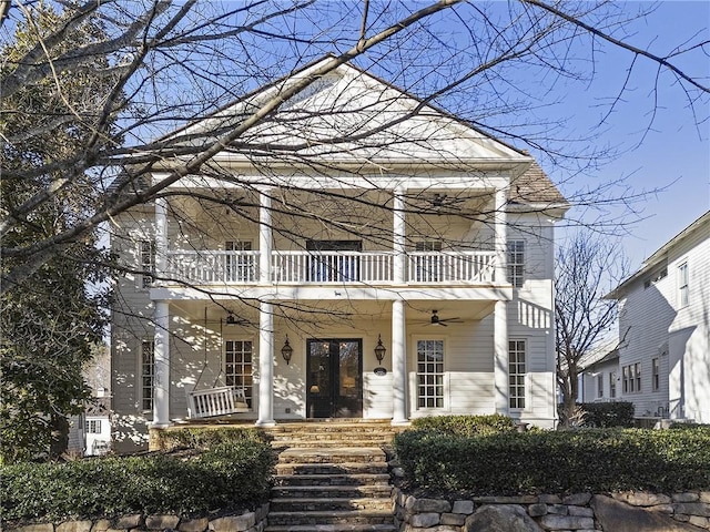 greek revival inspired property with ceiling fan, a balcony, and a porch