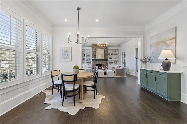 dining space with a fireplace, ornamental molding, a notable chandelier, dark wood-type flooring, and built in shelves