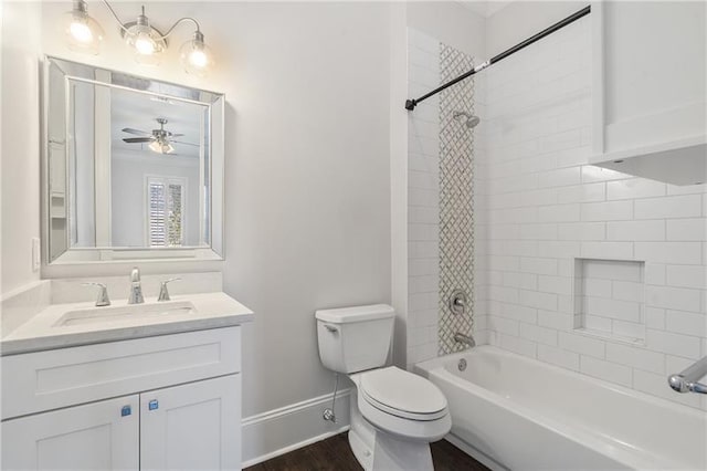 full bathroom with ceiling fan, tiled shower / bath combo, vanity, wood-type flooring, and toilet