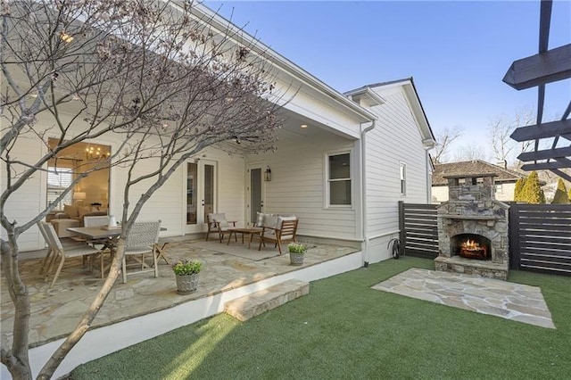 rear view of property featuring an outdoor living space with a fireplace and a patio