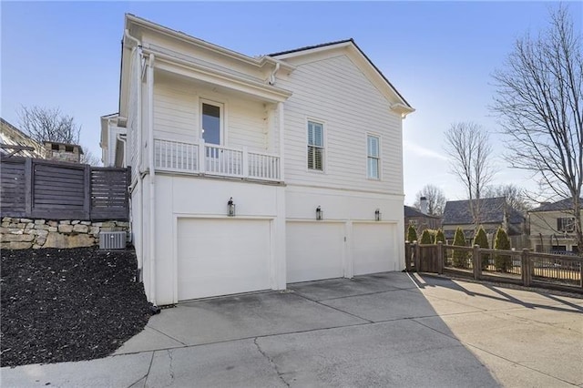 exterior space featuring a garage, a balcony, and cooling unit