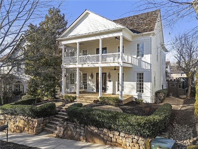 neoclassical home with ceiling fan, a balcony, and a porch