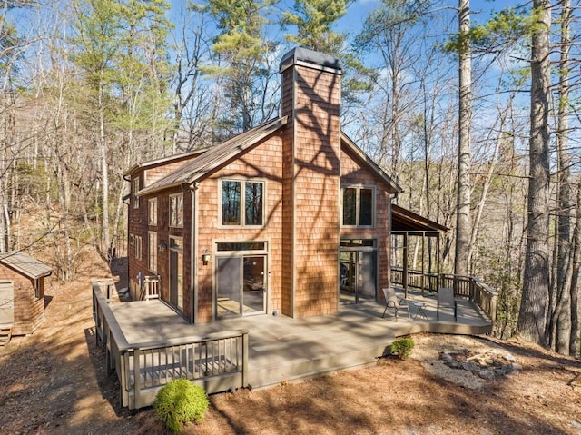 view of property exterior featuring a chimney and a wooden deck