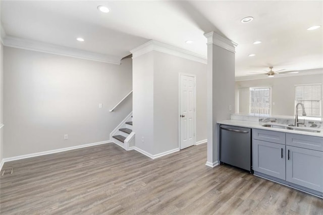 kitchen with gray cabinetry, a sink, stainless steel dishwasher, light wood-style floors, and ceiling fan