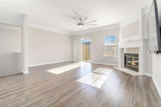 unfurnished living room featuring a high end fireplace, crown molding, a ceiling fan, and wood finished floors