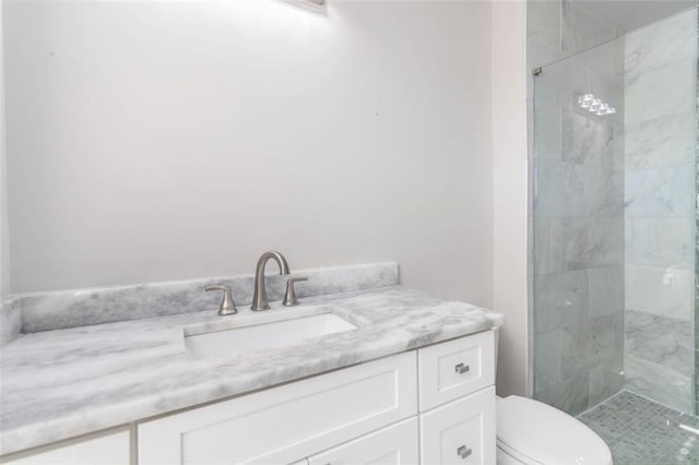 full bath featuring toilet, tiled shower, and vanity