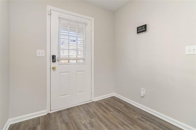 doorway to outside featuring wood finished floors and baseboards