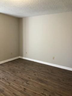 unfurnished room with dark hardwood / wood-style floors and a textured ceiling