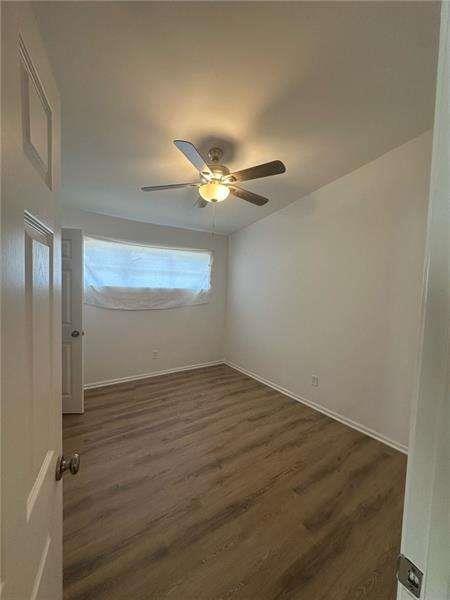 2041 Olive Springs Rd, Marietta, GA 30060 - spare room with baseboards, dark wood-type flooring, and a ceiling fan