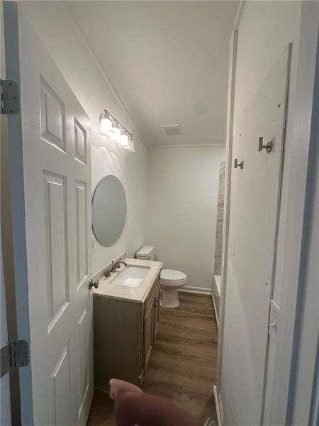 2041 Olive Springs Rd, Marietta, GA 30060 - bathroom with walk in shower, toilet, wood finished floors, vanity, and visible vents