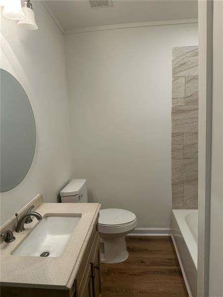 2041 Olive Springs Rd, Marietta, GA 30060 - full bathroom featuring toilet, wood finished floors, crown molding, visible vents, and vanity