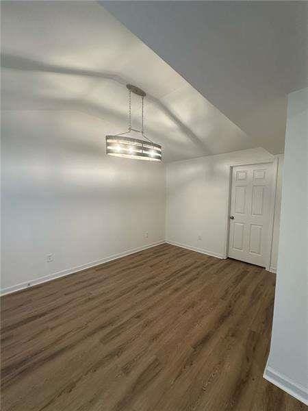 2041 Olive Springs Rd, Marietta, GA 30060 - unfurnished dining area with lofted ceiling, baseboards, and dark wood finished floors
