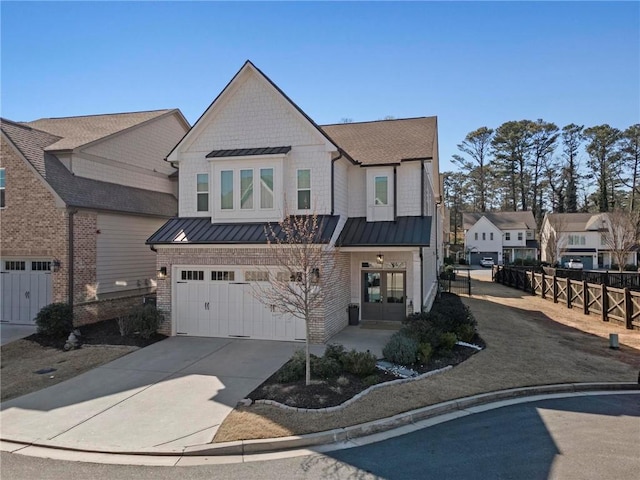 view of front of house featuring a standing seam roof, french doors, fence, and driveway