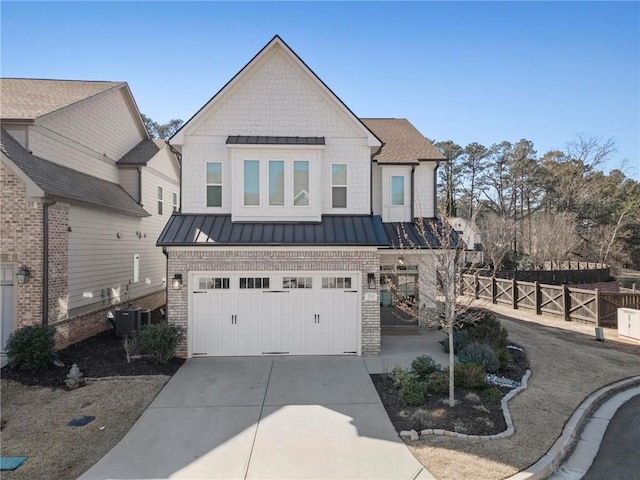 view of front facade with brick siding, concrete driveway, cooling unit, an attached garage, and a standing seam roof