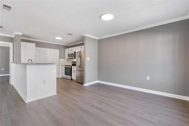 504 Mill Pond Ct, Smyrna, GA 30082 - kitchen with stainless steel appliances, crown molding, wood finished floors, white cabinets, and a peninsula