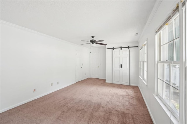 742 Redland Dr, Jonesboro, GA 30238 - unfurnished bedroom featuring a barn door, carpet, baseboards, and ornamental molding