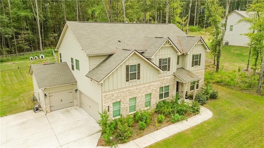 475 Mcdonough Rd, Fayetteville, GA 30214 - craftsman inspired home featuring board and batten siding, roof with shingles, a front lawn, and driveway