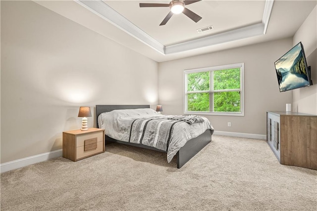 bedroom featuring carpet flooring, a tray ceiling, visible vents, and baseboards