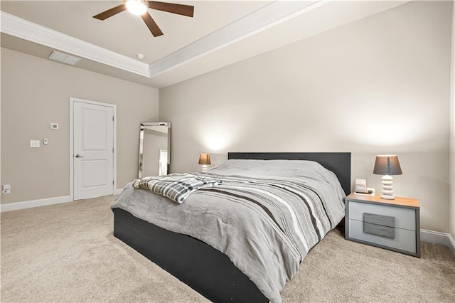 carpeted bedroom featuring ceiling fan, visible vents, baseboards, a raised ceiling, and ornamental molding