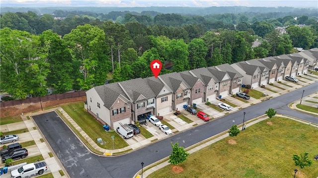 drone / aerial view featuring a view of trees and a residential view