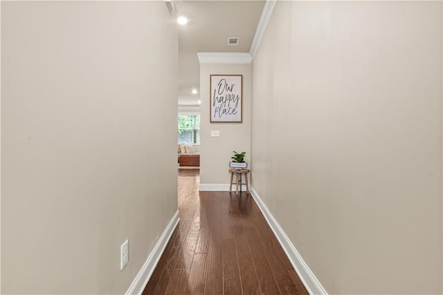 hall featuring crown molding, baseboards, dark wood-style floors, and visible vents