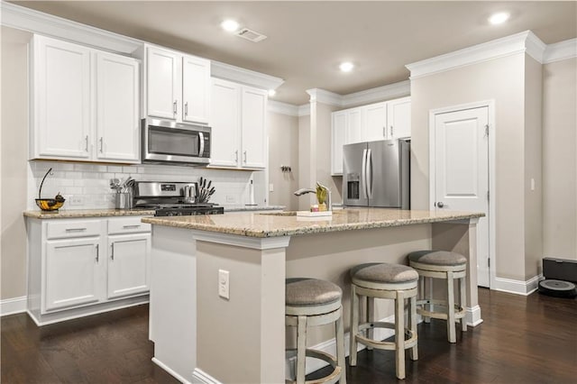 kitchen with crown molding, baseboards, stainless steel appliances, and visible vents