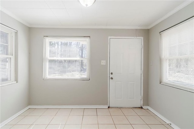 doorway to outside featuring light tile patterned flooring, crown molding, and baseboards