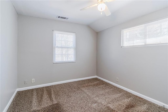 carpeted spare room featuring a ceiling fan, lofted ceiling, visible vents, and baseboards