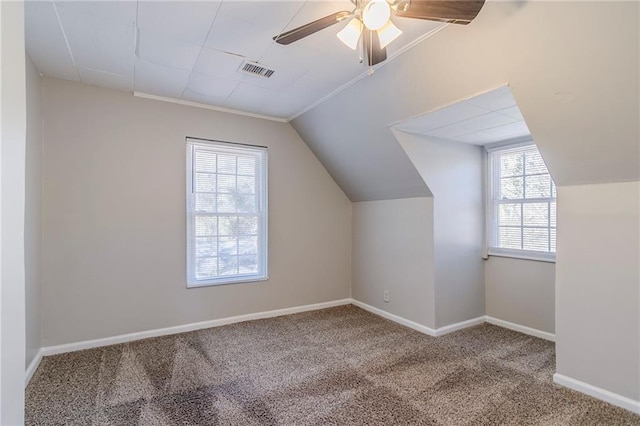 additional living space with lofted ceiling, visible vents, a ceiling fan, carpet flooring, and baseboards