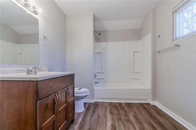 full bath with toilet, shower / bath combination, wood finished floors, vanity, and baseboards