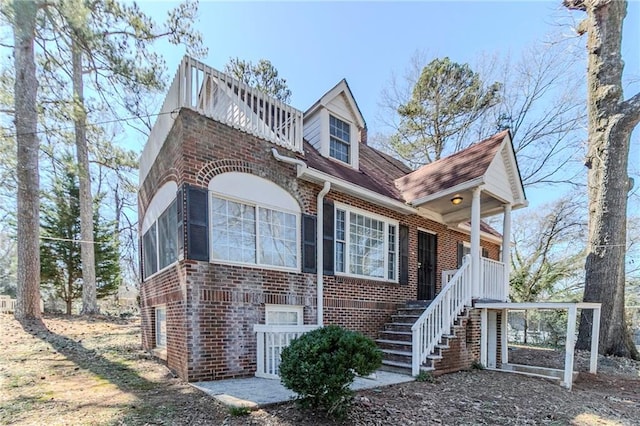 view of front of home featuring stairway and brick siding