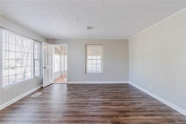 unfurnished room featuring ornamental molding, dark wood-type flooring, and visible vents