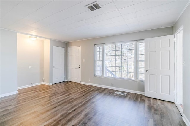 interior space featuring wood finished floors, visible vents, and baseboards