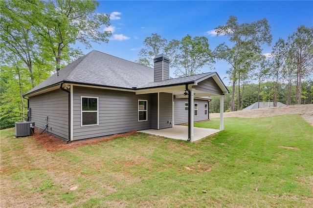 back of house featuring a lawn, a patio area, and central AC