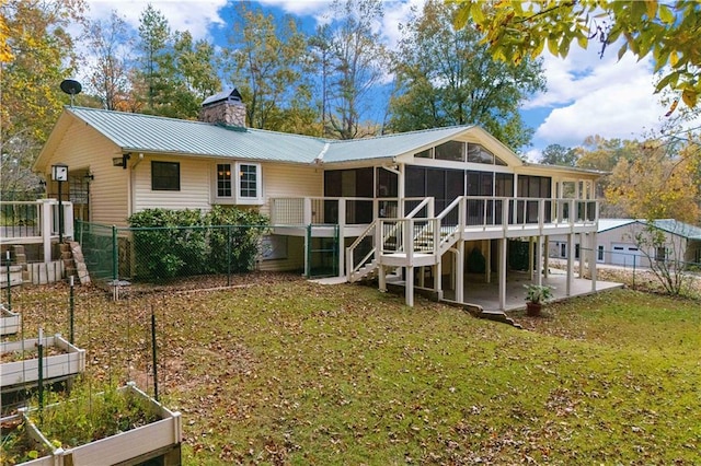 rear view of property with a sunroom, a patio area, and a lawn