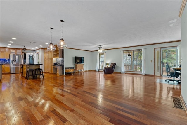 living room with ceiling fan, light hardwood / wood-style floors, and ornamental molding