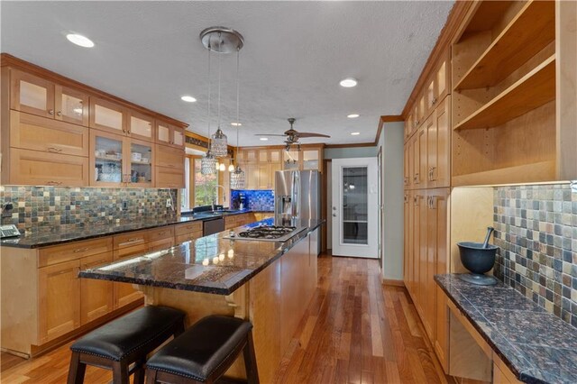 kitchen featuring a center island, decorative light fixtures, light hardwood / wood-style floors, and tasteful backsplash