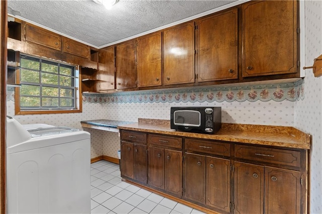 kitchen with light tile patterned floors, a textured ceiling, and washer / clothes dryer