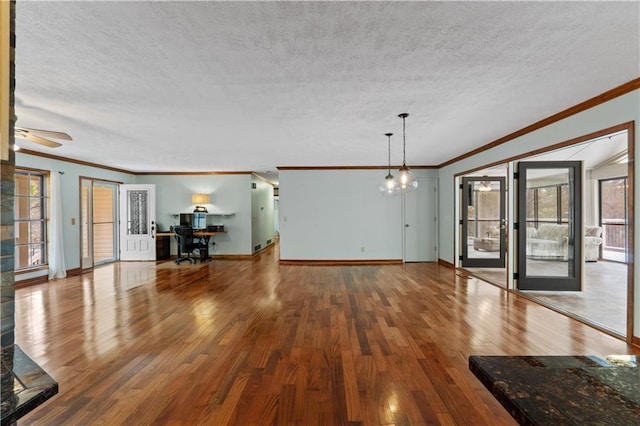 unfurnished living room with hardwood / wood-style floors, ornamental molding, and a textured ceiling