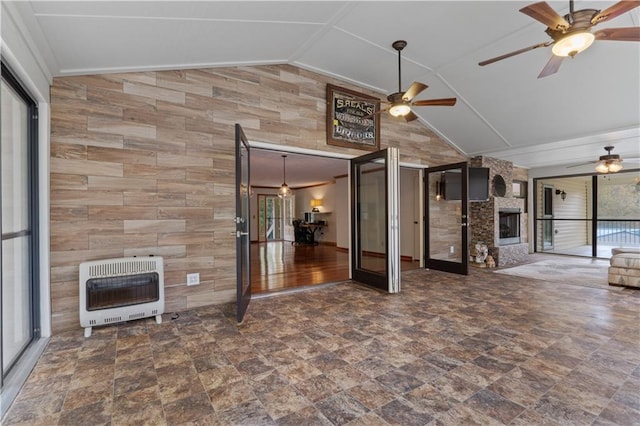 unfurnished living room featuring french doors, a large fireplace, heating unit, vaulted ceiling, and ceiling fan