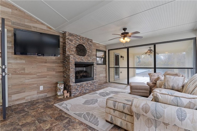 living room with ceiling fan, a fireplace, and wooden walls