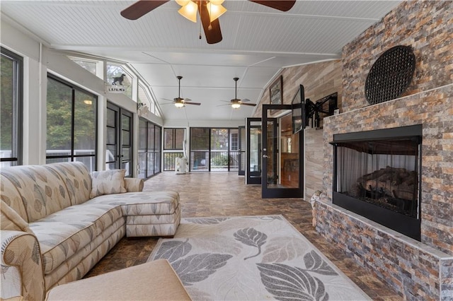 living room with a wealth of natural light, a fireplace, ceiling fan, and lofted ceiling with beams