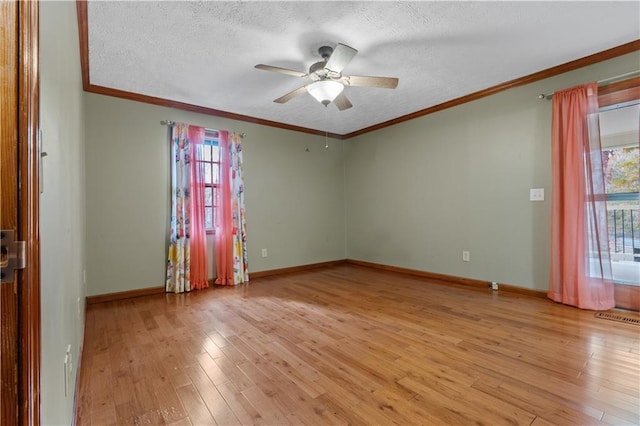 spare room featuring ceiling fan, plenty of natural light, a textured ceiling, and light wood-type flooring