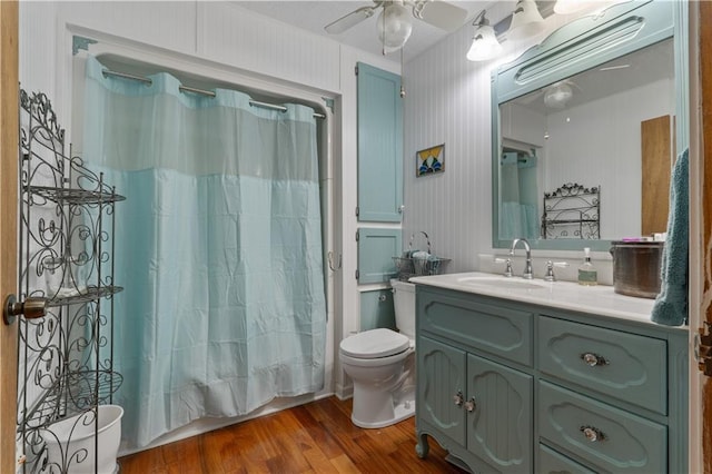 full bathroom with shower / bath combo, vanity, ceiling fan, wood-type flooring, and toilet