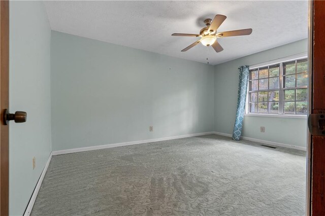 carpeted empty room with a textured ceiling and ceiling fan