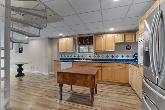 kitchen featuring stainless steel fridge with ice dispenser, light hardwood / wood-style flooring, dishwasher, and a healthy amount of sunlight