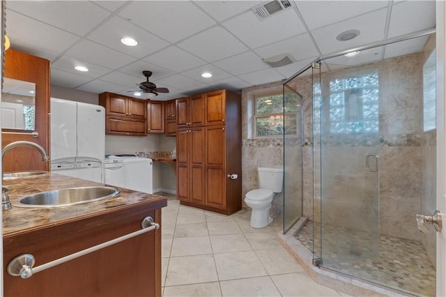 bathroom featuring walk in shower, vanity, ceiling fan, independent washer and dryer, and toilet